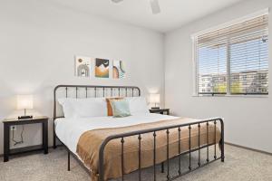ein Schlafzimmer mit einem Bett mit zwei Tischen und einem Fenster in der Unterkunft Stunning Westgate CozySuites by stadium w pool 7 in Glendale