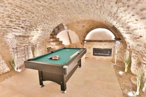 una mesa de billar en una habitación con una pared de ladrillo en Le Speakeasy - Maison avec billard en Auxerre