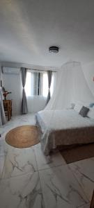 1 dormitorio con 1 cama con edredón blanco en Résidence au bout du Morne en Le Morne
