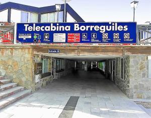 a building under construction with a sign that reads telacco bacco forensics at SKI & SNOW APARTMENTOS by TODOSIERRANEVADA - Plaza Principal Junto a los Telecabinas in Sierra Nevada