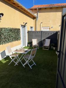 a patio with chairs and a table and a fence at Studio cosy, proche Poitiers in Nieuil-lʼEspoir