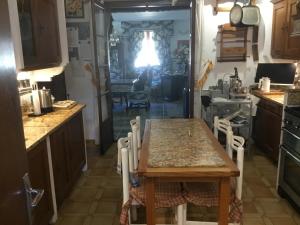 una cocina con mesa y sillas. en Villa la Cerisaie., en Reynès