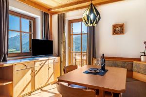 a dining room with a table with a television and a dining room at Häuslerhof App Pinus in Villabassa