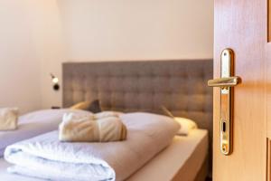 łóżko z dwoma białymi poduszkami w obiekcie Häuslerhof App Pinus w mieście Villabassa
