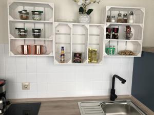 una cocina con armarios blancos y fregadero en Luxliv Apartements, en Balingen