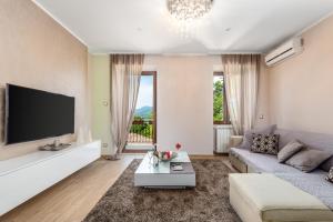 een woonkamer met een bank en een tv bij Apartment Srok, Romantic in Kastav