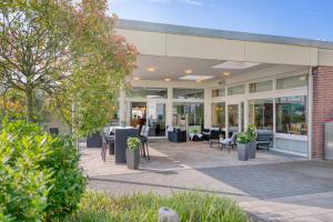 een gebouw met een patio met tafels en stoelen bij Hotel Wiehen-Therme in Hüllhorst