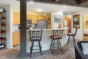 a kitchen with two bar stools at a counter at Lodge at Steamboat A203 in Steamboat Springs