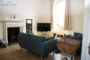 a living room with two blue couches and a television at Linton in Kinghorn