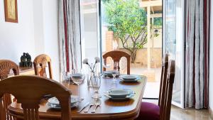 una mesa de comedor con platos y vasos. en VILLA ROSARIO entre Granada y Sierra Nevada, en La Zubia