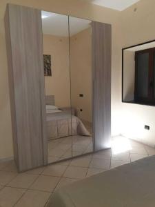 einen Spiegel in einem Zimmer mit einem Bett und einem TV in der Unterkunft La Domus Pompei Casa vacanza in Pompei