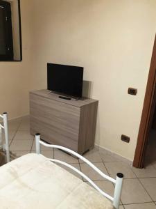 ein Wohnzimmer mit einem TV auf einer Kommode in der Unterkunft La Domus Pompei Casa vacanza in Pompei
