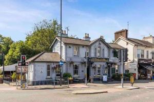 a white building on the corner of a street at Lavender Lodge - Near Shops & with Free Parking in Haywards Heath