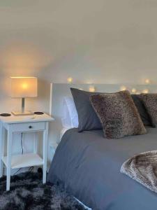 a bedroom with a bed and a table with a lamp at Lavender Lodge - Near Shops & with Free Parking in Haywards Heath