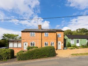 a brick house with bushes in front of a street at Pass the Keys Traditional Comfy 2 Bed in Alderminster in Stratford-upon-Avon