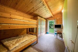 een slaapkamer in een blokhut met een bed en een bureau bij Kleines Gästehaus in Sudwalde
