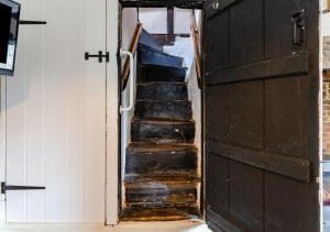 un tramo de escaleras en una habitación con puerta en No.36 Debenham, en Debenham