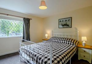 una camera con un letto con una coperta a scacchi di Black Tiles a Dennington