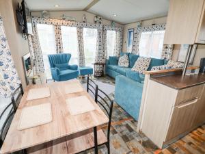 a kitchen and living room with a table and a couch at Beachcomber D35 in Abergele