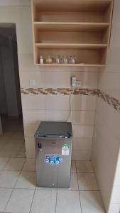a small refrigerator in a kitchen with a shelf at Bliss Escapes in Ruiru