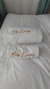 duas toalhas numa cama com as palavras febre azul em Bliss Escapes em Ruiru
