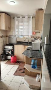 a kitchen with a counter with a sink and a stove at Bliss Escapes in Ruiru