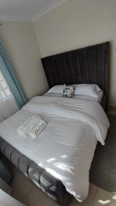 uma grande cama branca com duas almofadas em Bliss Escapes em Ruiru