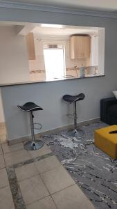 a living room with two stools in front of a counter at Bliss Escapes in Ruiru