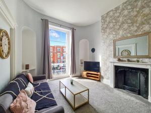 a living room with a couch and a fireplace at Margaret's Terrace in Cheltenham