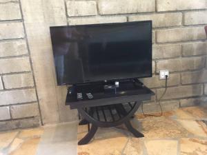 a flat screen tv on a black table against a brick wall at Modern Studio/Apt overlooking Pool/Ocean view in San Juan del Sur