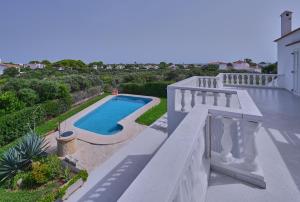 a swimming pool on the balcony of a house at Villa Savanna Spacious villa with private pool near the beach in Cala en Blanes