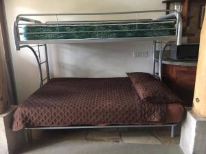 a bedroom with a bunk bed with a brown comforter at Modern Studio/Apt overlooking Pool/Ocean view in San Juan del Sur