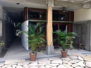 a building with two potted plants in front of a building at Modern Studio/Apt overlooking Pool/Ocean view in San Juan del Sur