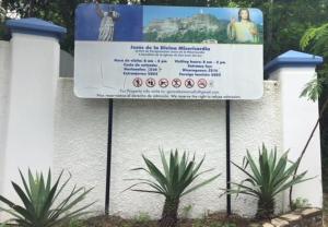 a sign in front of a wall with two plants at Modern Studio/Apt overlooking Pool/Ocean view in San Juan del Sur