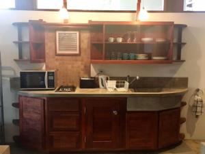 cocina con encimera y microondas en Modern Studio/Apt overlooking Pool/Ocean view, en San Juan del Sur