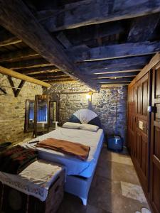 a bedroom with two beds and a stone wall at Helvacılar Konağı in Karacasu