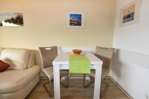 a dining room table with chairs and a couch at Haus Jan am Strand Wohnung - 215 in Cuxhaven