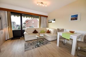 a living room with a couch and a table at Haus Jan am Strand Wohnung - 215 in Cuxhaven