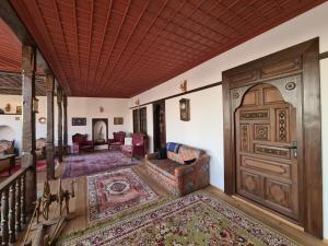 una sala de estar con una gran puerta de madera en Helvacılar Konağı en Karacasu