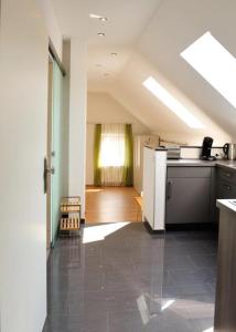 eine Küche im Dachgeschoss mit einer Theke und einem Kühlschrank in der Unterkunft Weingut Edling in Roßdorf