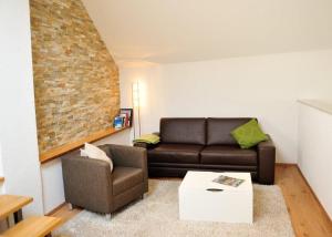 uma sala de estar com um sofá e uma cadeira em Weingut Edling em Roßdorf