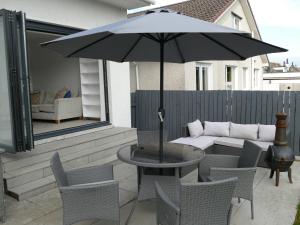 a table and chairs with an umbrella on a patio at The Annexe in Eaglesham