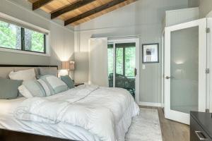 Un dormitorio con una gran cama blanca y una ventana en Treetop Getaway by Sarah Bernard Chalets, en Innsbrook