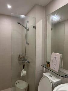y baño con ducha de cristal y aseo. en AZURE URBAN RESORT RESIDENCE R&C - Parañaque en Manila