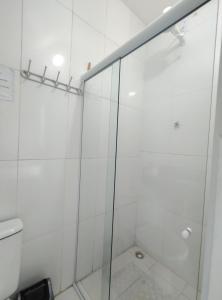 een douche met een glazen deur in de badkamer bij Kitnet em Serrinha, Bahia in Serrinha