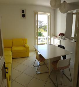 - un salon avec une table et un canapé jaune dans l'établissement Villa joy, à Calendasco