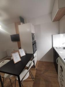 a small kitchen with a black table and a sink at L'aventure Top destination ski in Aragnouet