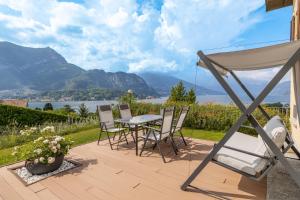 a patio with a table and chairs and mountains at Villa La Perla - Bellagio in Bellagio