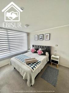 a bedroom with a large bed with a window at EBISUR Apart - Hoteles MAIPU in Concepción