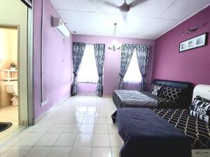 uma sala de estar com paredes roxas e um sofá em E&A Homestay KLIA/ Sepang/ Nilai em Sepang